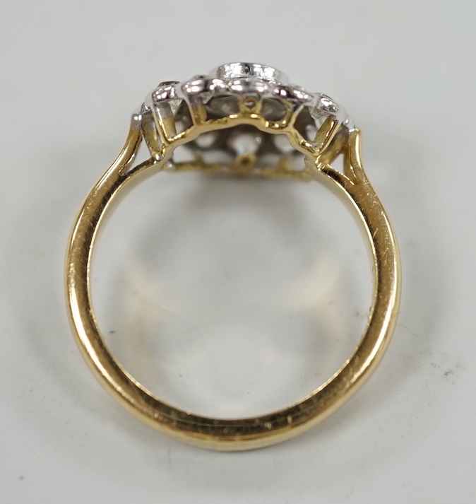 An 18ct and illusion set diamond circular cluster ring, size N, gross weight 5.1 grams.